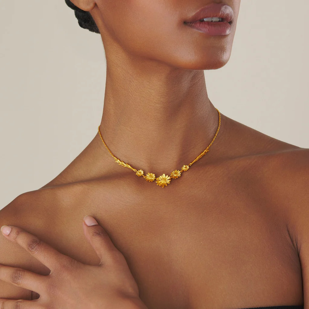 Gold floral necklace on model